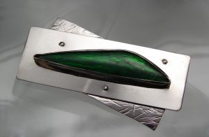 Metal sheets with a green gem