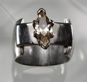 A silver band with a clear crystal