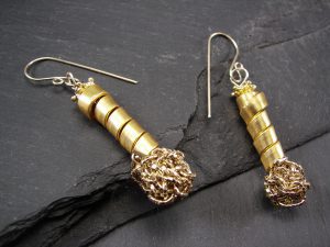 A pair of gold wool earrings with a twisted design