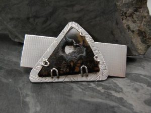 A metallic charm with a black stone