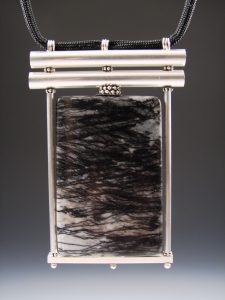A pendant with silver rods and a gray stone