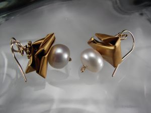 A pair of gold earrings with pearls