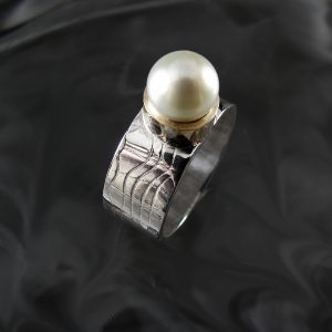 A silver ring with a white pearl