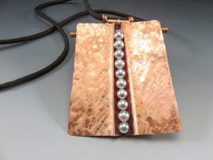 A bronze pendant with pearls