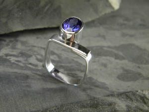 A silver ring with a blue gem