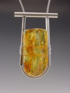 A silver necklace with an amber pendant