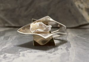 A silver charm with a pearl stone
