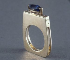 A silver band with a blue gem